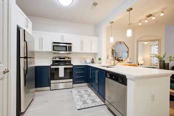 a kitchen with blue and white cabinets and stainless steel appliances